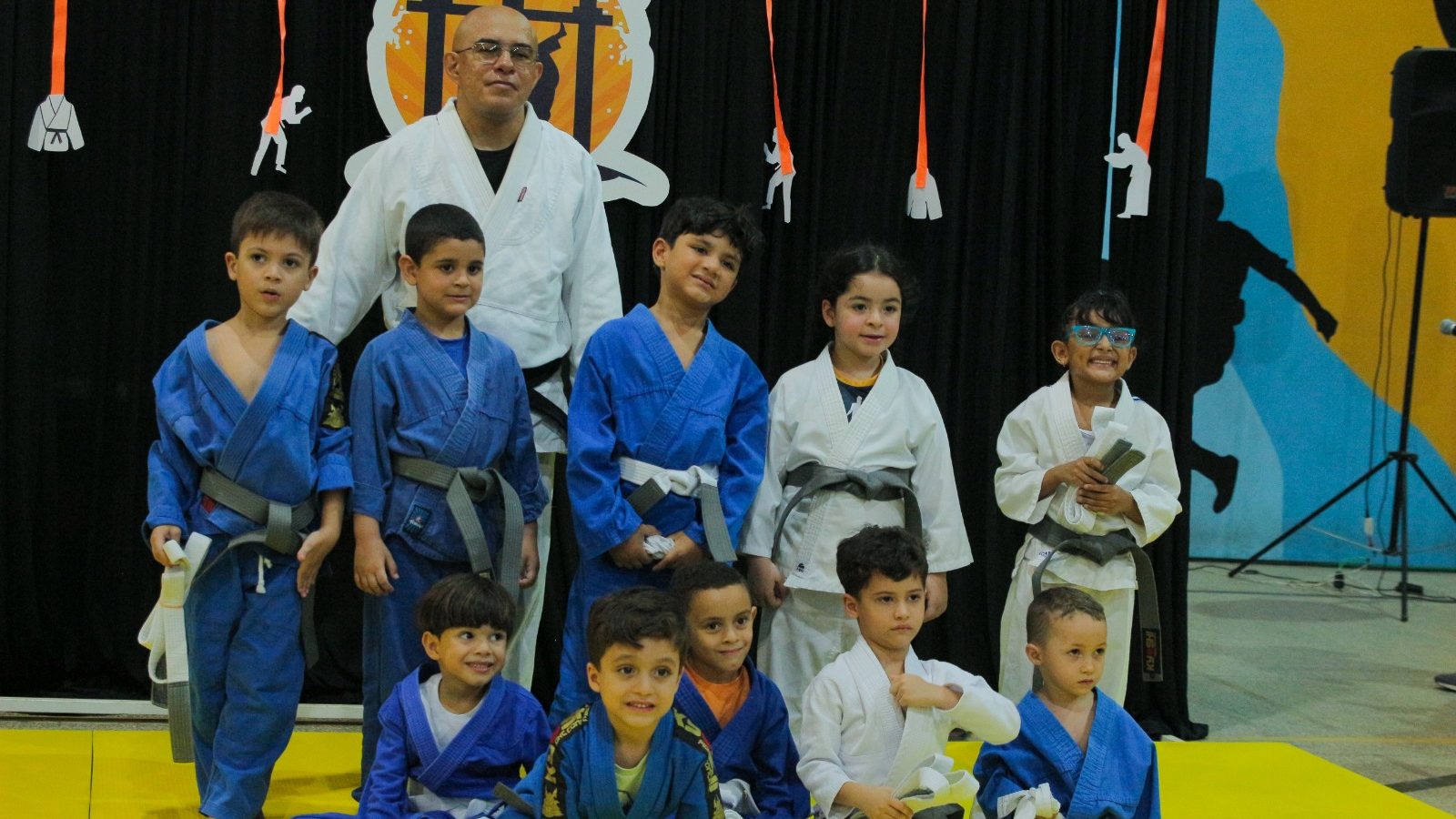 Crianças trocam de faixa no judô praticado na escola